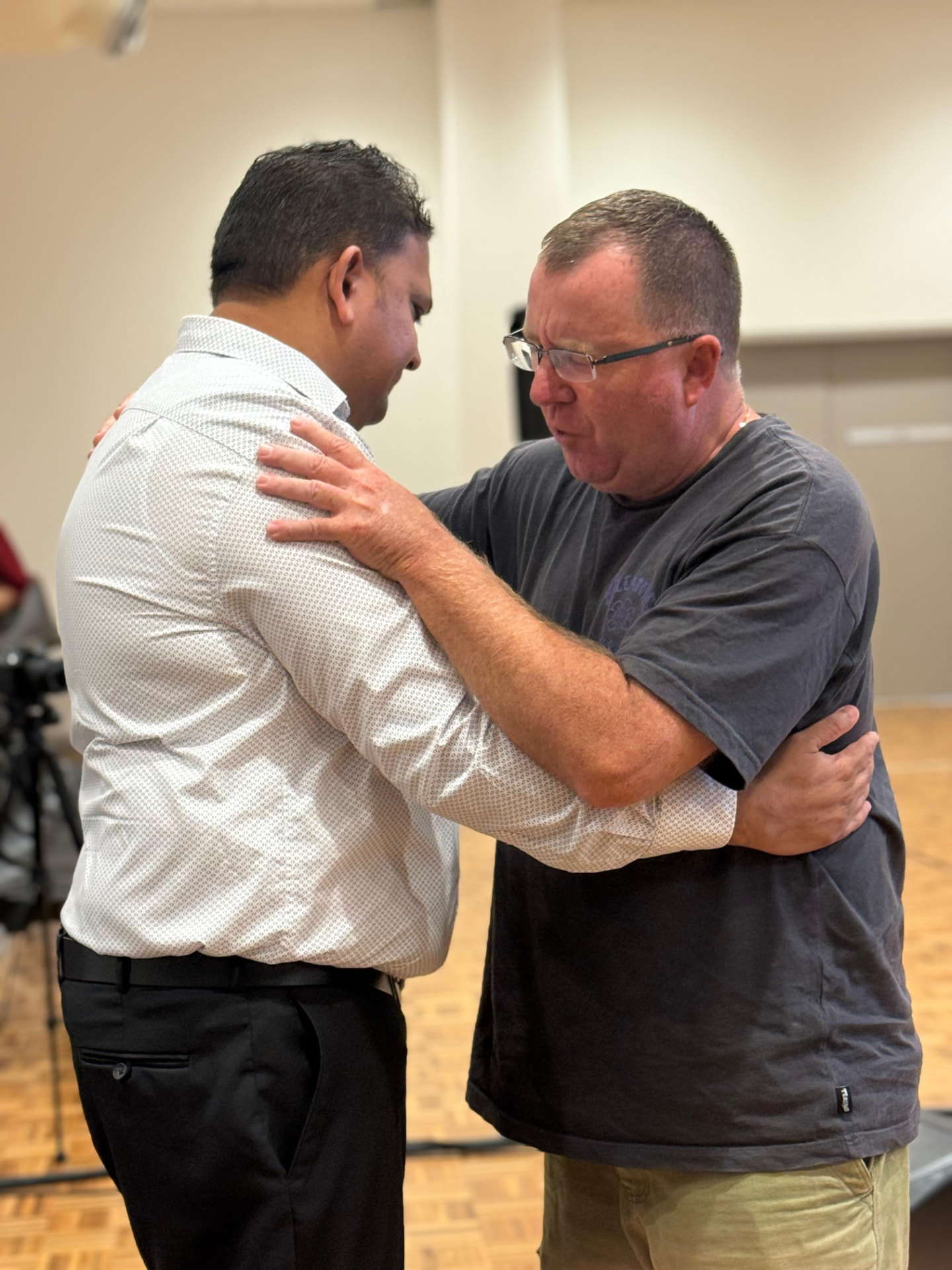 Two men praying together after a service