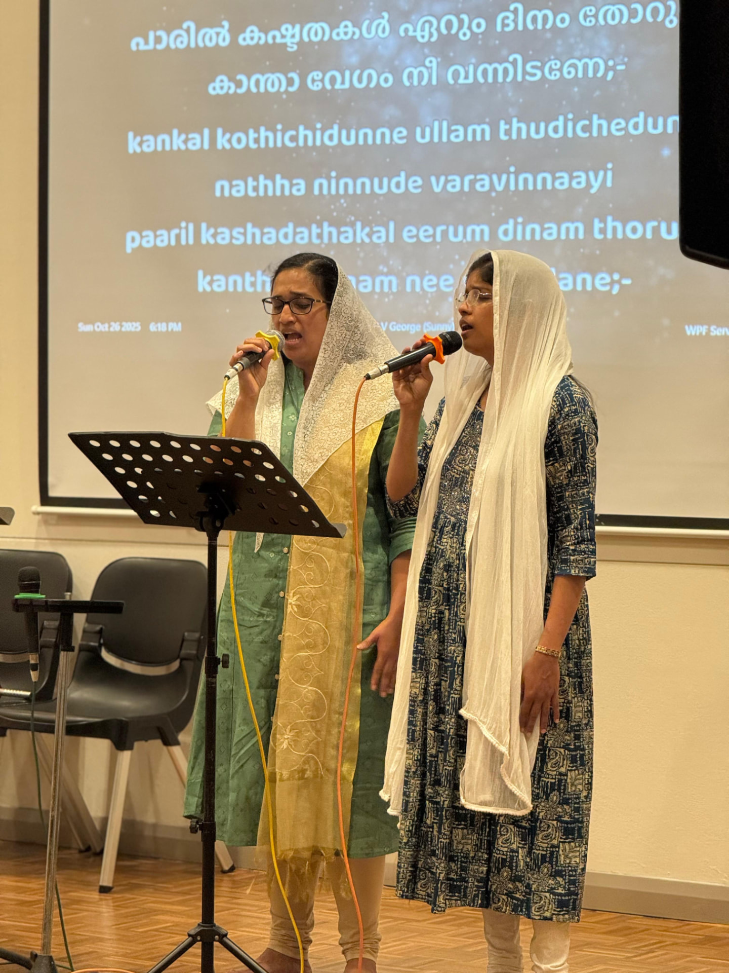 Two ladies singing a Malayalam hymn